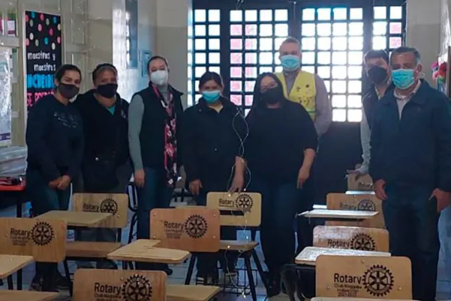 Llevan rotarios pupitres a escuela
