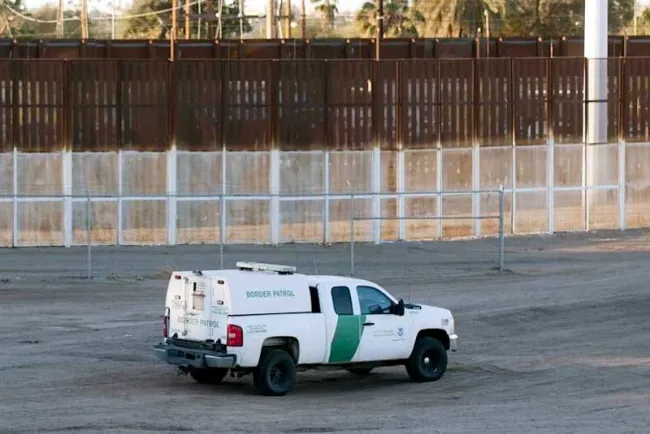 Muere migrante al quedar colgada en muro