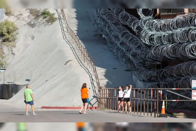 Retiran alambre de puas de muro fronterizo