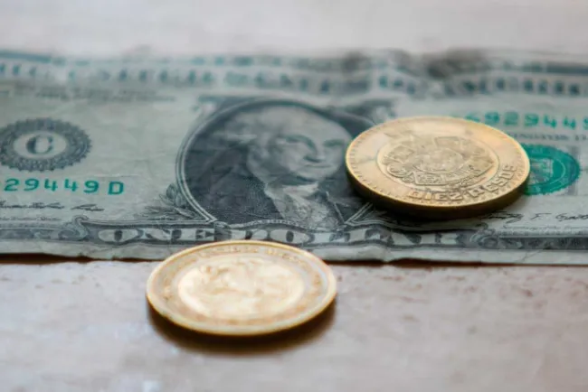 Pierde el peso, pero no rebasa las 23 unidades por dólar