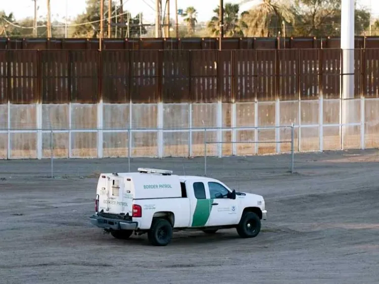 Muere migrante al quedar colgada en muro